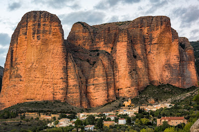 pero passán per Riglos, perque va volé vore los Mallos, aquelles peñes que pareixen martells en renglera, en lo mánec embutit a la montaña.