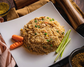 a plate of fried rice garnished with carrot and celery sticks