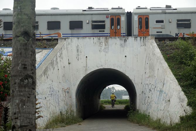 Memotret pesepeda yang melintasi jalan lorong