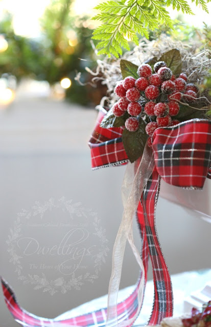 Red berries with a plaid bow dress up an ironstone compote filled with a rabbits foot fern.