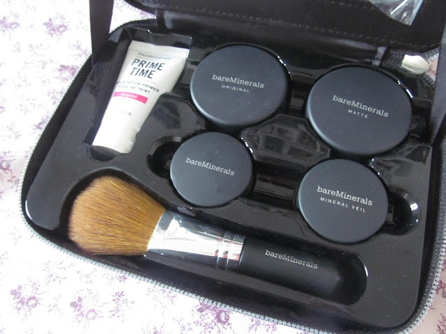 four black tubs, a brush and white tube in black case