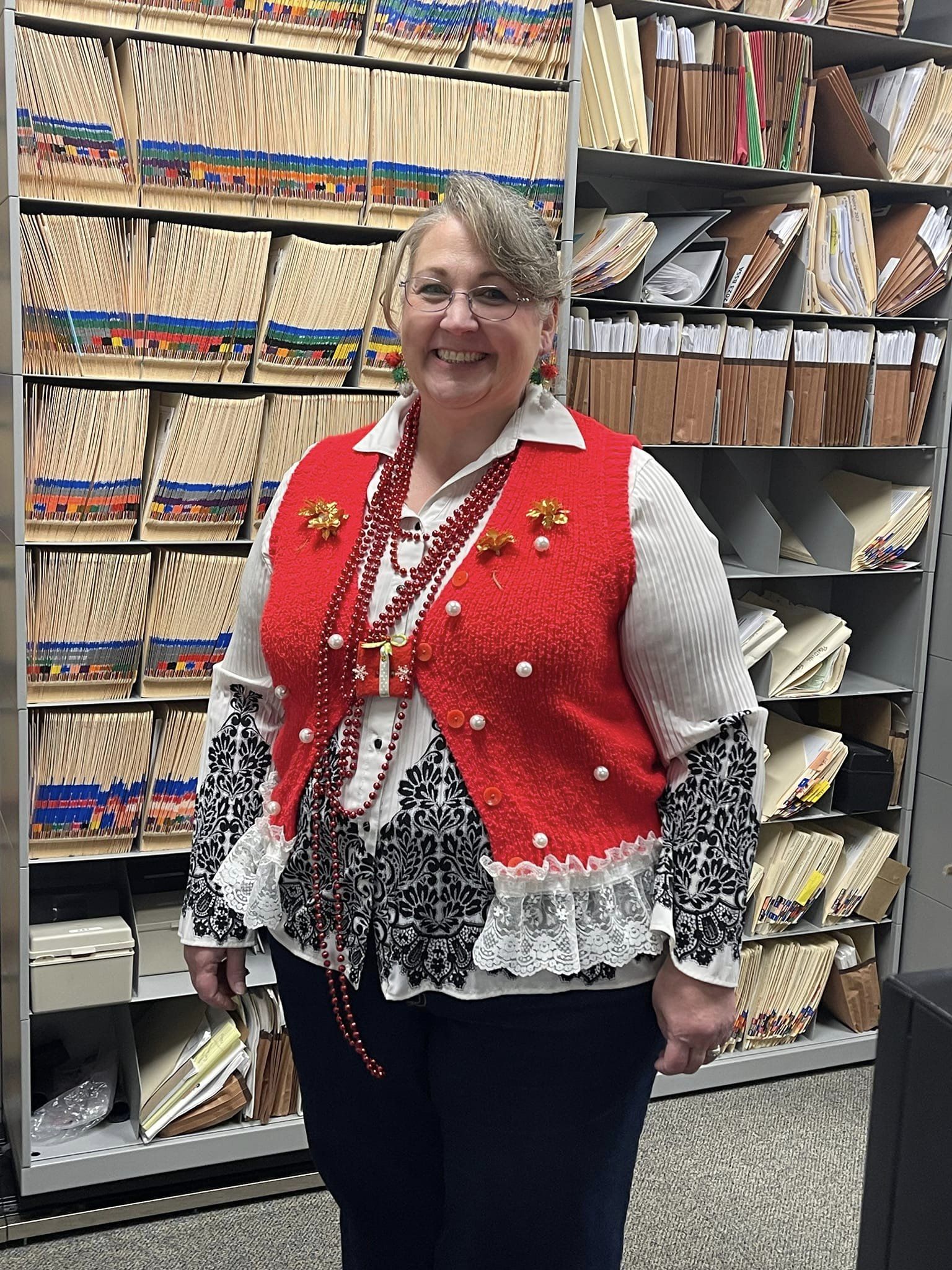 woman in file room wearing christmas sweater