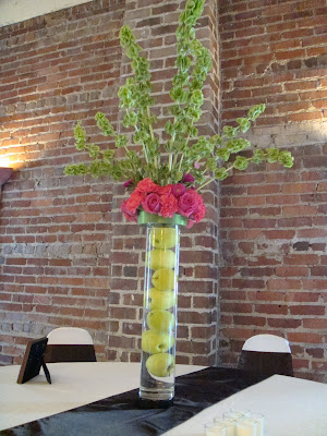 Tall centerpieces consisted of 20 tall cylinder vases filled with green 