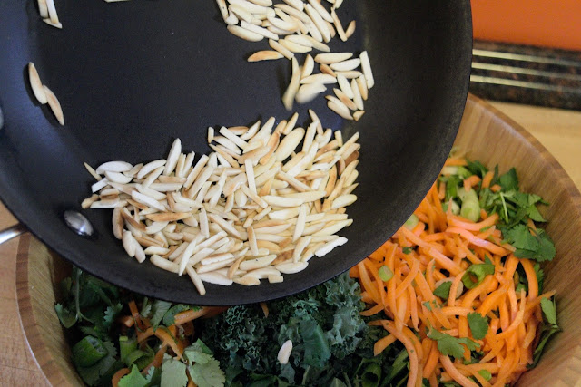 Toasted almonds being added to the salad.