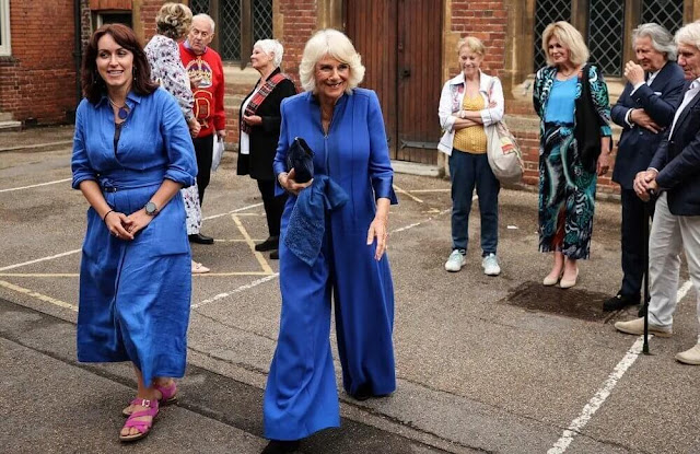 Queen Camilla wore a navy blue jumpsuit with ultra wide-leg trousers by Anna Valentine. Queen's Reading Room Literary Festival