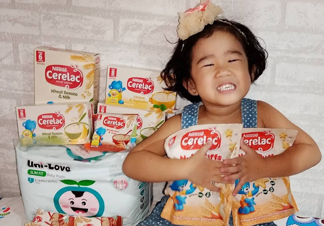 cute baby holding cerelac nutripuffs