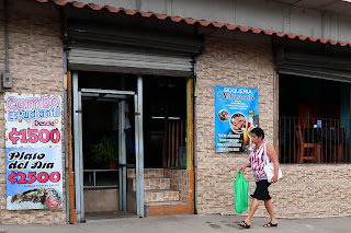 Woman walking by restaurant in Puriscal.