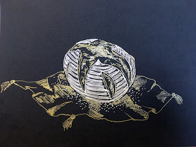 A horizontal pen drawing on black paper, of a white and gold boule of bread, set on a rumpled, tassel-cornered gold napkin. The bread is white on the outside with flour, and shows gold where it's been slashed.