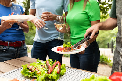 people enjoying food and drinks at backyard cookout