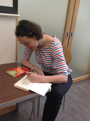 The author Sarah Courtauld sits down and signs books