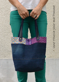 Sac à main Cabas en jeans recyclés montés façon patchwork horizontalement , sac semi-rigide, surpiqures roses , tissu ethnique en extérieur et par petites touches, poche en jeans utilisable appliquée à l'extérieur avec rappel du tissu ethnique, intérieur coton violet, deux poches à soufflet intérieurs en jeans et biais rose, anses en jeans et cuir noir véritable rivetées mains, se ferme à l'aide d'un aimant. Dimensions : 32 x 26 x 15 cm, anse : 60 cm.