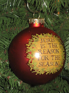 Giant Red bauble decorated in Christmas tree labeled with Jesus is the reason for the season letters photo