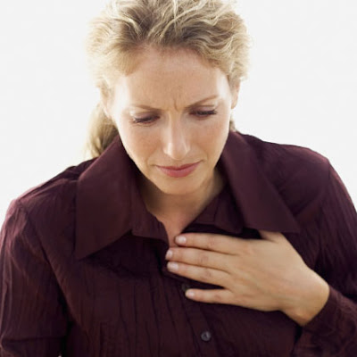 Woman with heart burn clutching her chest