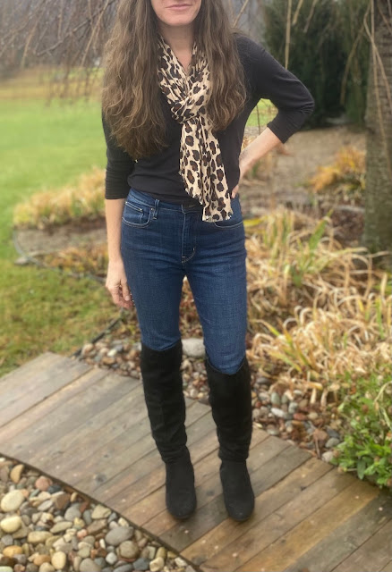 woman in black shirt, cheetah print scarf, tall black boots and jeans