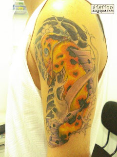 Carpa dourada tatuada no braço.