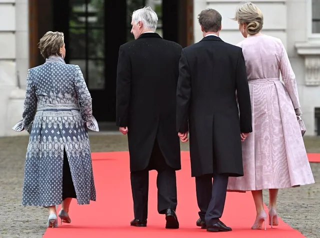 Grand Duchess Maria Teresa wore a blue boucle coat by Dries Van Noten. Queen Mathilde wore a pale pink dress by Natan