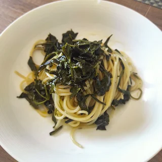Piatto con spaghetti e sopra rucola e olio di oliva