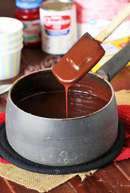 Homemade Chocolate Sauce Running Off Spatula Into Saucepan Image