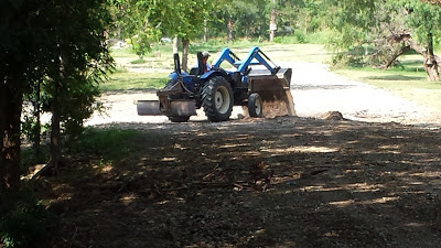 Tractor filling the holes and leveling the roads