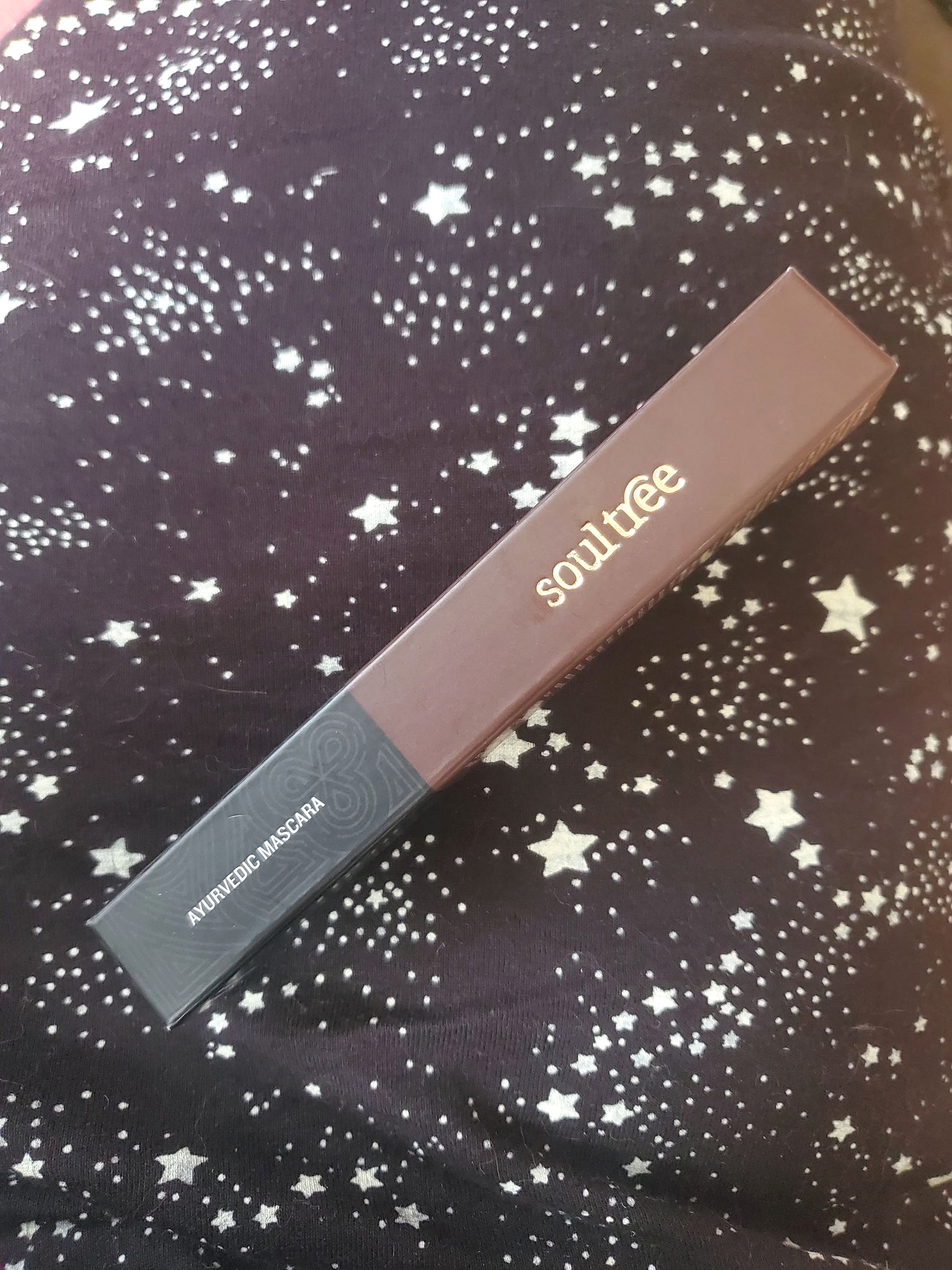 Pure Black mascara from SoulTree on dark starry background