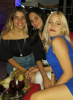 La cubana camila sentada junto a sus 2 amigas en un bar.