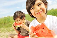 crianças comendo melancia