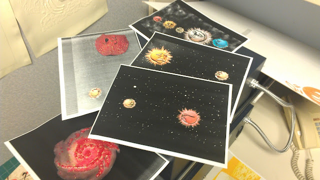 On top of the black EZ-Brailler sits many mold pages drying.  One is of the spiral Milky Way galaxy which is cloudy and given texture with red puff paint.  There is also the globular cluster (round, red and very bumpy) and Little Star (yellow and smiling and small), Little Star (yellow and smiling) meeting Big Daddy (a red star with sunglasses, a large nose and a goatee), Little Star meeting Mr. Old-Timer Orange Star (orange with a white mustache and large nose), and the line up of stars: a red star with sunglasses, Big Daddy; orange star, Mr. Old-Timer Orange Star; yellow star, Little Star; white star, Pearl; and blue star, Mr. Angry Blue-White Star on a red background.