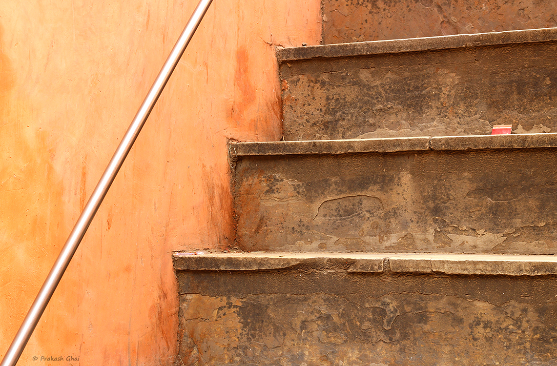 A minimalist photo of an orange colored Ascending Staircase