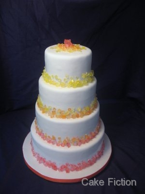 orange and yellow colors to decorate this four tier white wedding cake