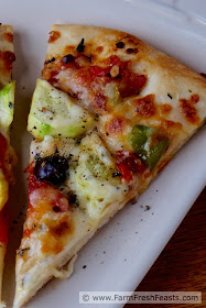 This pizza is a vegetarian's Late Summer Dream. Squash, peppers, olives and slow-roasted tomatoes covered with cheese.