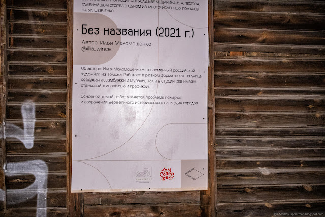 Информационный плакат на стене деревянного дома