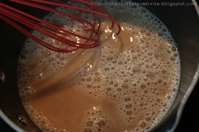 Whisk stirring latte coffee mixture in a pot on the stove