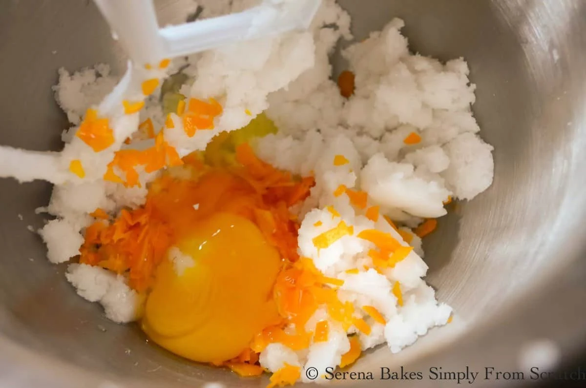 Orange Zest, Eggs, and Vanilla with the creamed sugar in a mixing bowl for Orange Cranberry Muffins.