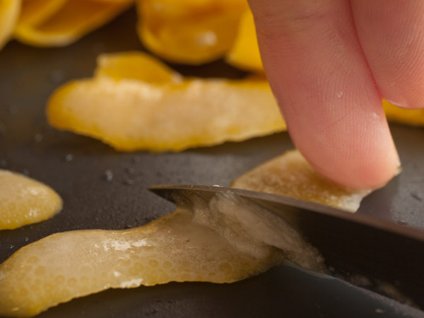 Scraping pith from blanched lemon peel
