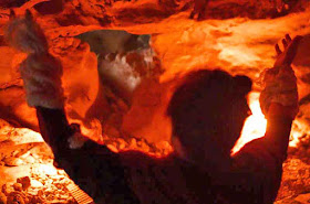 A spiritual person praying in front of fire in a cave, Kouri-jima, Okinawa