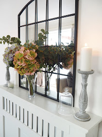 How to style a radiator cover in your living room using accessories and items you already own including artificial greenery, candles and flowers.