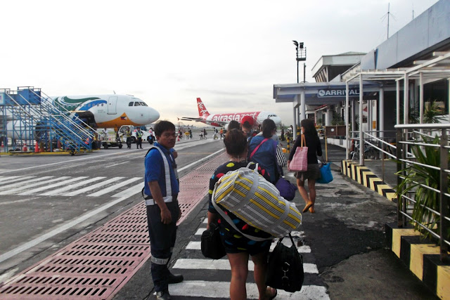 passengers walking on the tarmac to board a plane at NAIA Terminal 4