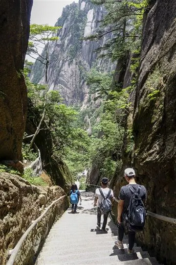Tourists thread their way through a narrow pass on Huangshan. As the number of visitors to these areas grows each year, authorities are increasingly under pressure to manage access and the environmental impact of tourism. 