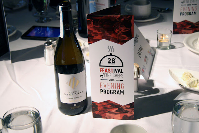 Program for FEASTival and a bottle of win on the table