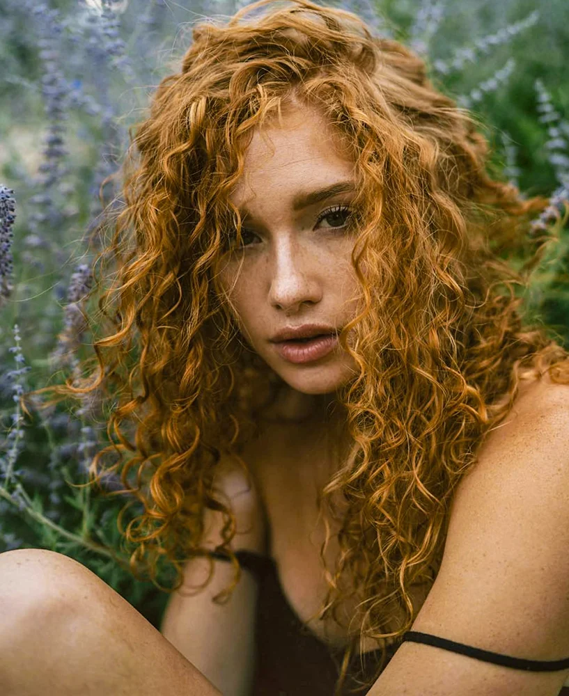 beautiful woman with a curly, rustic red hair color