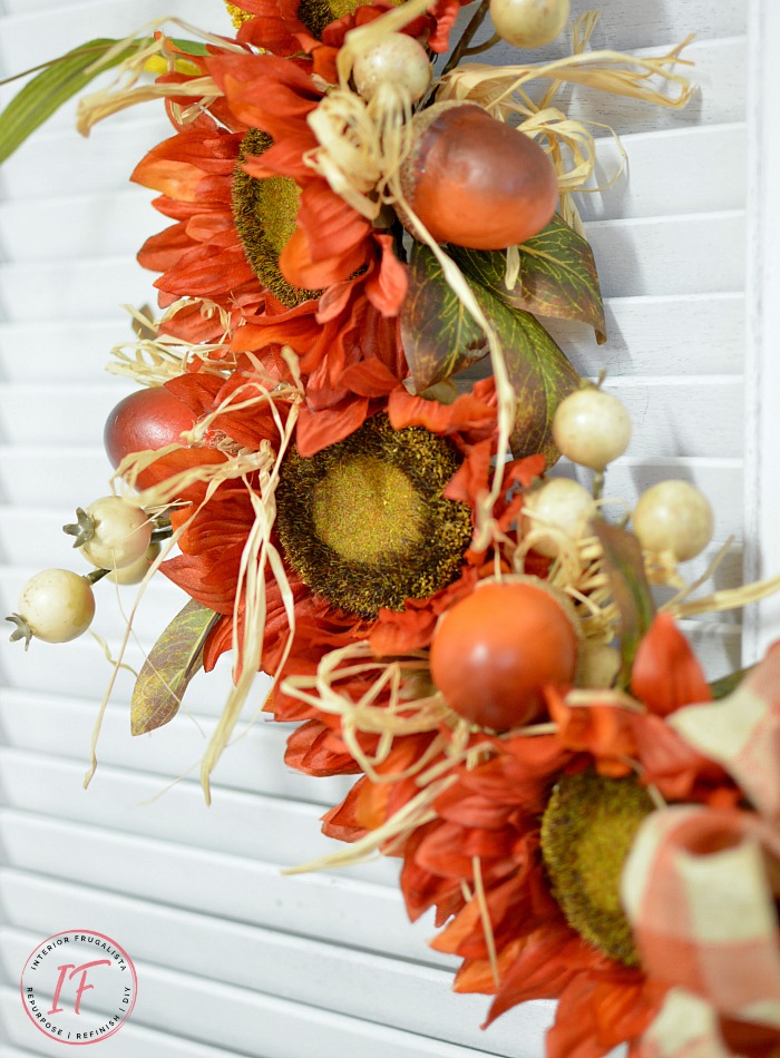 An easy orange sunflower fall wreath DIY idea in bright traditional autumn colors and a recycled grapevine wreath, a budget-friendly fall door wreath.