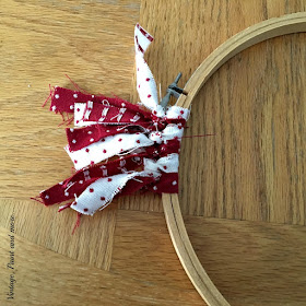 tying fabric strips onto embroidery hoop for a Valentine wreath