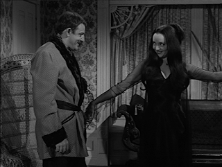 Morticia showing off her new nightgown to Gomez