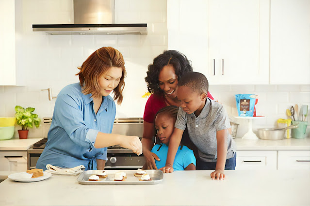 two women with two children in kitchen baking:Photo by American Heritage Chocolate on Unsplash