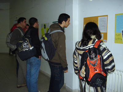 Alumnos contemplando con atención los carteles