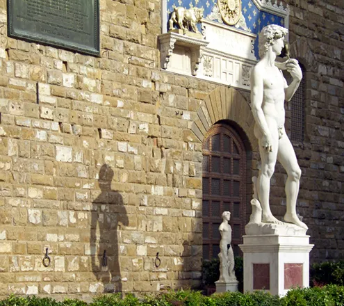 imagen de El David de Miguel Ángel Buonarroti junto a la entrada principal de del Palazzo Vecchio (Palacio Viejo) de la Plaza de la Señoría de Florencia, copia de la escultura por Arrighetti