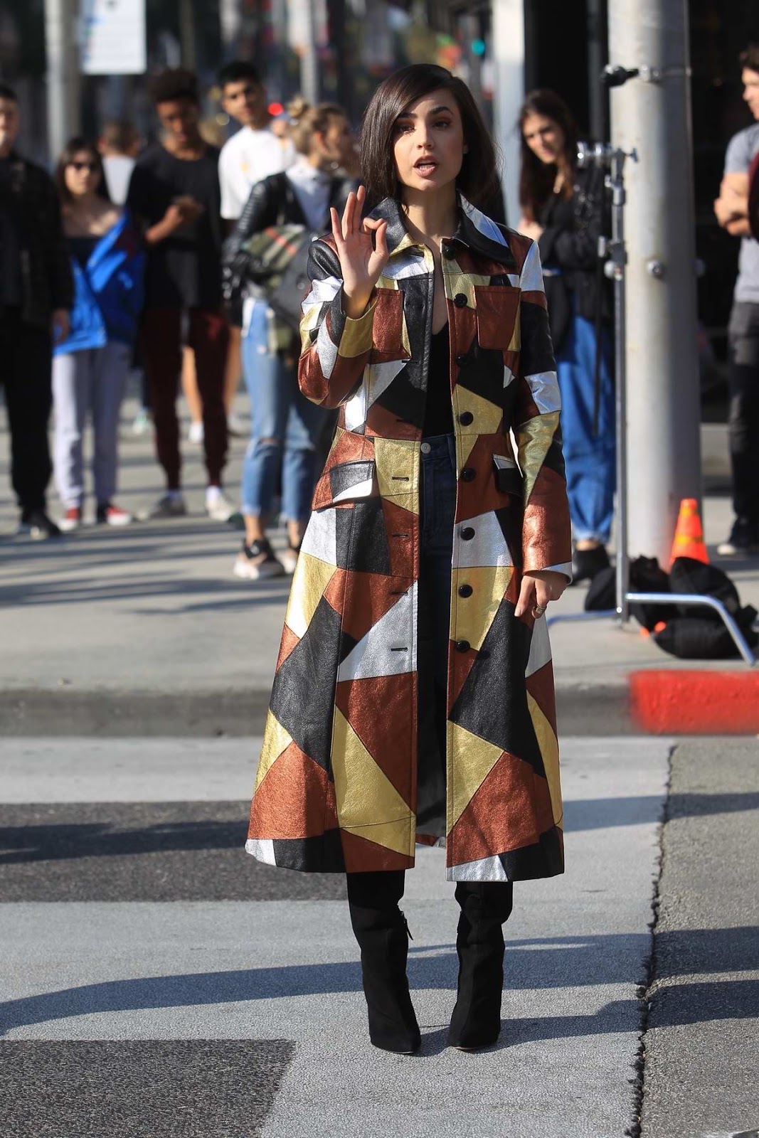 Sofia Carson in a multi-colored long coat during a sidewalk interview on Rodeo Drive in Beverly Hills, California