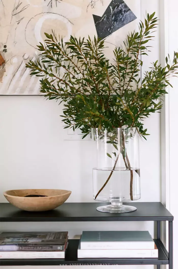 Console table with vase of greenery and bowl