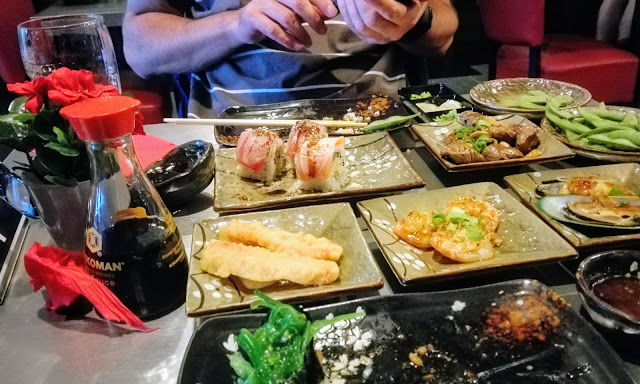 Uitgebreide tafel met hapjes tijdens All you can eat sushi.