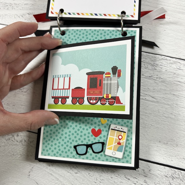 Disney themed scrapbook album page with a train flip-up card, cell phone, and glasses